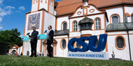 Dobrindt und Söder stehen vor dem Kloster Andechs neben einer SChrift CSU in fetten blauen Buchstaben