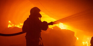 Feuerwehrmann steht in den Flammen.