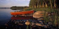 Ein rotes Ruderboot an einem See in Finnland
