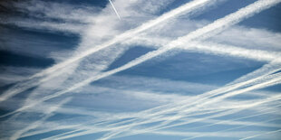 Kondensstreifen teilen einen blauen Himmel