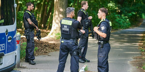 Polizisten stehen am Eingang eines Waldgebietes in Zehlendorf