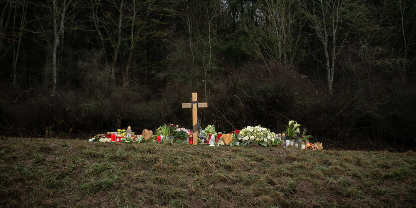 Ein Kreuz und Kerzen an deiner Gedenkstelle an einer Landstraße.