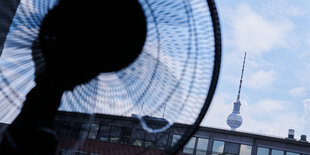 Ein Ventilator in einem Raum, im Hintergrund der Fernsehturm