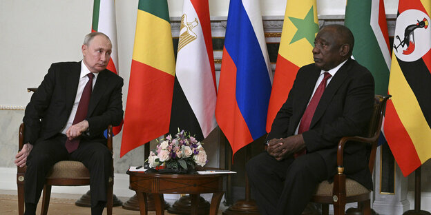 Russlands Präsident Putin und Südafrikas Präsident Ramaphosa vor Flaggen.