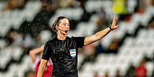 Franziska Wildfeuer in schwarzer Schiedsrichterkleidung auf einem Fußballplatz.