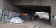 Zelte von Obdachlosen unter einer Brücke.