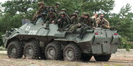 Soldaten hocken auf einem Panzer