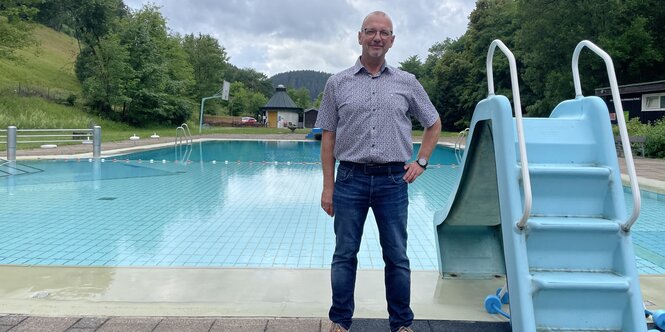 Reinhold Hasse, zweiter Vorsitzender des Spiegelbads in Wildemann, steht vor dem Schwimmerbecken des Freibads.