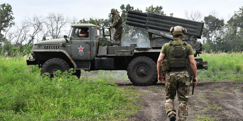 Russische Soldaten an einem Militärfahrzeug.