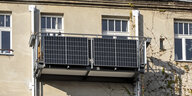An einer Fassade ist ein Balkon mit angebrachten Solarpanelen zu sehen