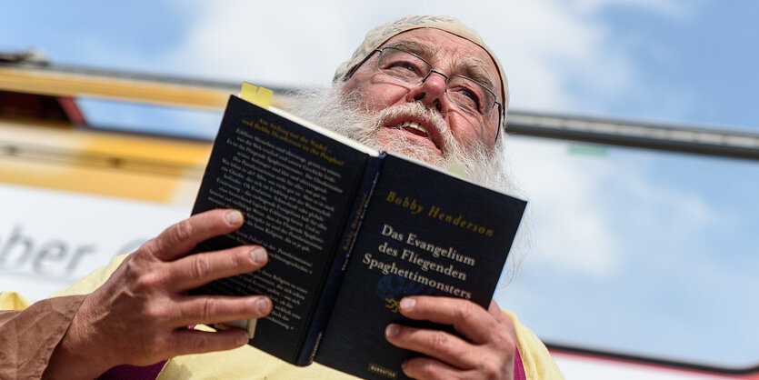 Ein Mann hält ein Buch in den Händen