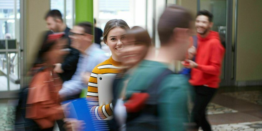 Studierende mit guter Laune im Eingangsbereich einer Universität