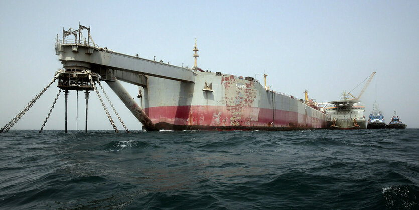 Ein am Boden festgemachter Tanker im Meer, Beiboote an der Seite