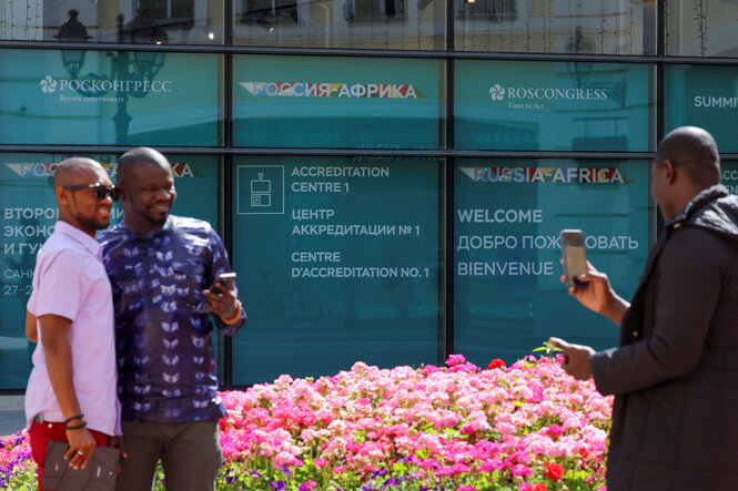 Männer posieren für ein Foto vor dem Akkreditierungsgebäude des Russland-Afrika-Gipfels