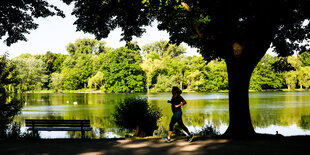 Eine Frau joggt am Morgen am Maschsee in Hannover entlang.