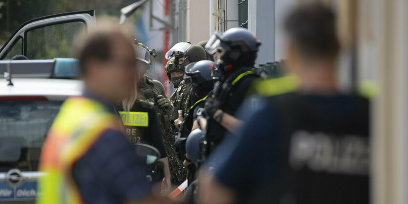 Spezzialkräfte der Polizei stehen vor einem Haus