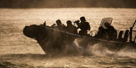 bewaffnete Militärs auf einem Schlauchboot