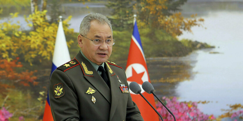 Russlands Verteidigungsminister spricht vor einer nordkoreanischen Fahne