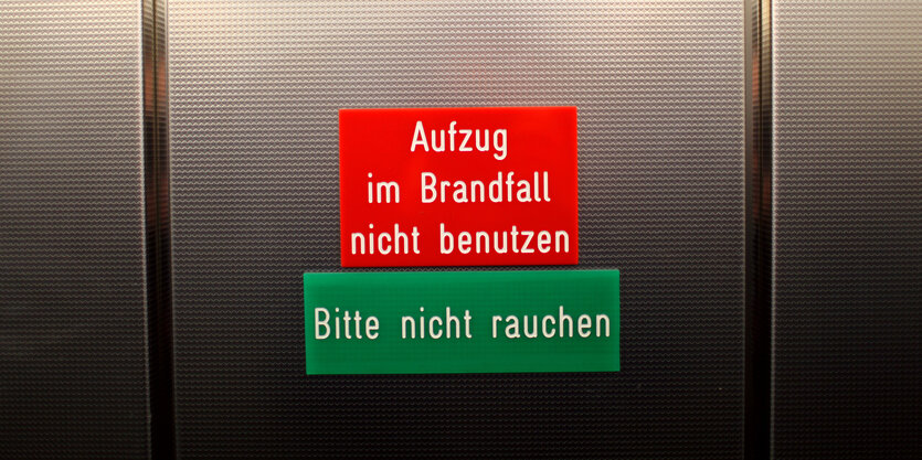 Metalltür mit Schild "Aufzug im Brandfall nicht benutzen"