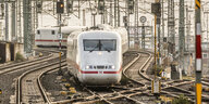 Ein ICE fährt in Frankfurt durch eine Gewimmel von Stromleitungen und Schienen