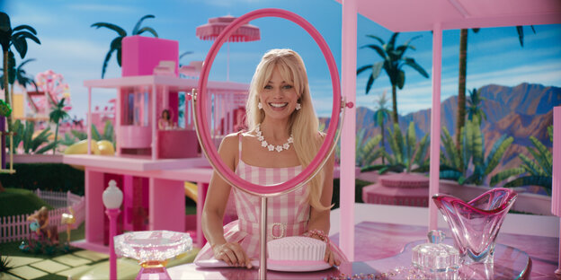 Barbie (Margot Robbie) sitzt in Barbieland an ihrem pinken Schminktisch.