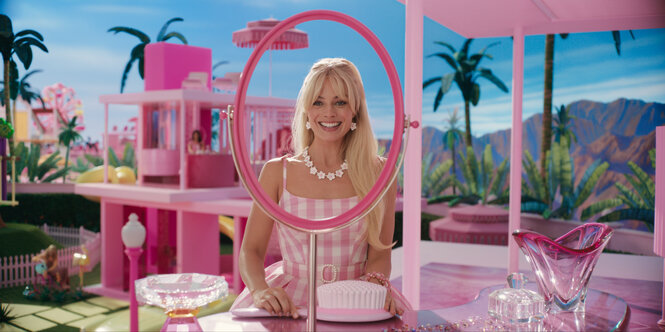 Barbie (Margot Robbie) sitzt in Barbieland an ihrem pinken Schminktisch.