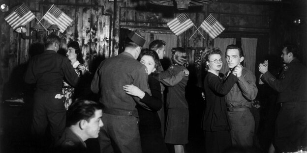 US-Soldaten tanzen mit jungen Frauen in einer Bar in Frankfurt, die mit US-Wimpeln geschmückt ist