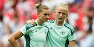 Lea Schüler umarmt die traurige Alexandra Popp, beide im hellgrünen Trikot der Nationalmannschaft