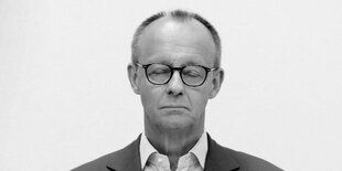 Friedrich Merz mit Brille, Hemd und Krawatte schaut ernst in die Kamera