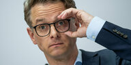 Carsten Linnemann hält sich seine Brille