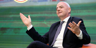 Infantino sitzt im Sessel und breitet die Arme aus