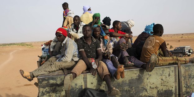 Junge Afrikaner sitzen auf einer LKW-Ladefläche
