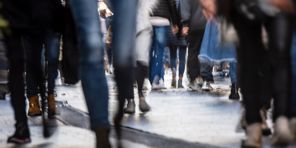 Passanten gehen durch die Innenstadt. Ein Bild, das unscharf aufgenommen wurde. Ein Symbolbild zur Kolumne "Die Fußgängerin"