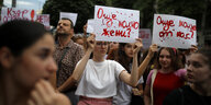 Frauen halten weiße Plakate mit roter Schrift in die Höhe. Darauf seht: "Wie viele Frauen noch?"