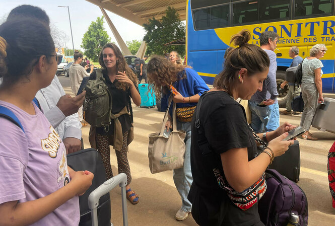 Menschen mit Gepäck an einem Bus