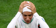 Fußballerin Nouhaila Benzina fasst sich an den Kopf.