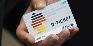 Ein Deutschlandticket wird in der Hand gehalten