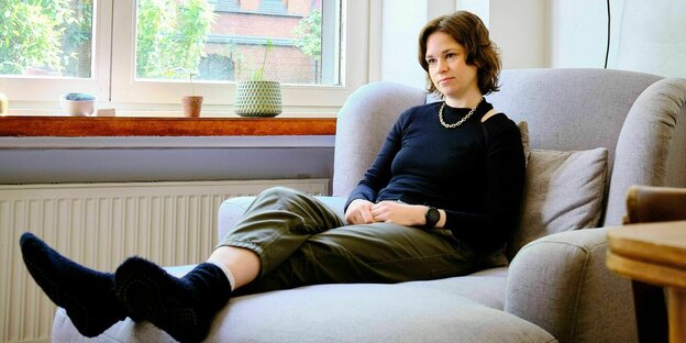 Sonja Trautmann sitzt auf einem Sofa in ihrer Wohnung