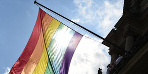Eine Regenbogenflagge weht vom Hamburger Rathaus