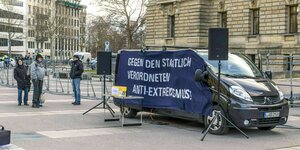 Kundgebung vor dem Bundesverwaltungsgericht mit einem Bus auf dem ein Banner angebracht ist: Gegen den staatlich verordneten Anti-Extremismus