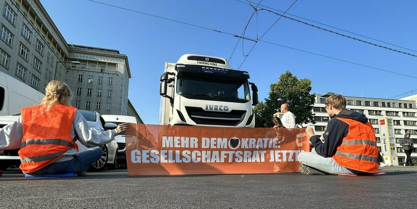 Orangene Banner vor einem LKW auf der Straße