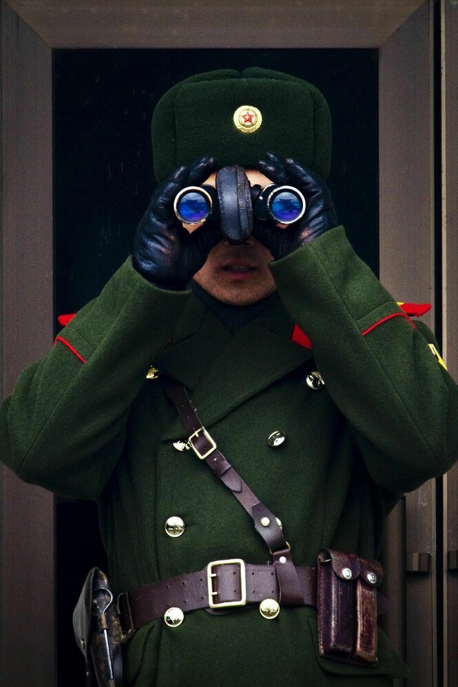 Ein nordkoreanischer Soldat mit Fernglas vor den Augen