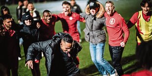 Trainer und Mannschaft tanzen im Kreis