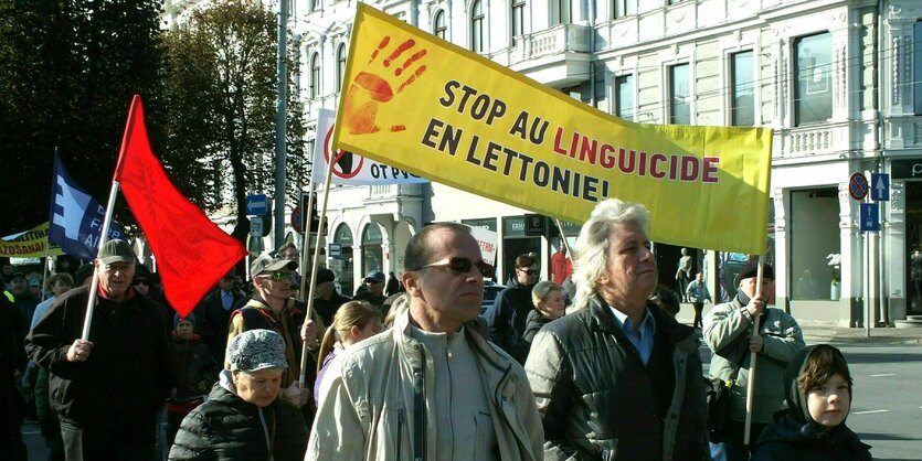 Russischsprachige Bewohner Lettlands protestieren mit einem Transparent: „Stop au Linguicide en Lettonie“ gegen die Abschaffung der russischen Sprache in den Schulen