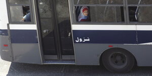 Eine Frau blickt aus einem geöffneten Fenster in einem Bus