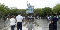 Menschen beten vor einer Statue