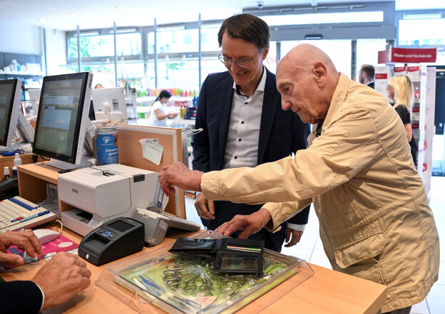 Gesundheitsminister Lauterbach mit einem älteren Mann in einer Apotheke.