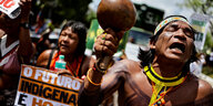 Mehrere Indigene mit Schildern auf einer Demonstration.
