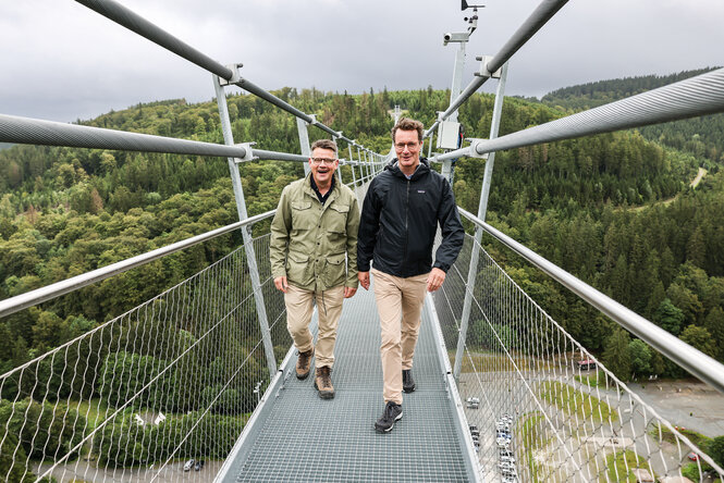 Hendrik Wüst (r, CDU), Ministerpräsident von Nordrhein-Westfalen und Boris Rhein (CDU), Ministerpräsident in Hessen, gehen über die Hängebrücke Skywalk in Willingen