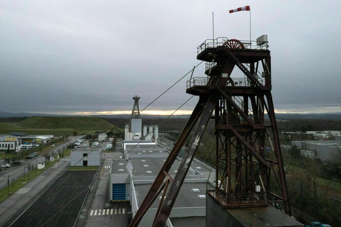 Blick auf die beiden ehemaligen Förderturm der Mine zwischen denen Flachdachgebäude stehen